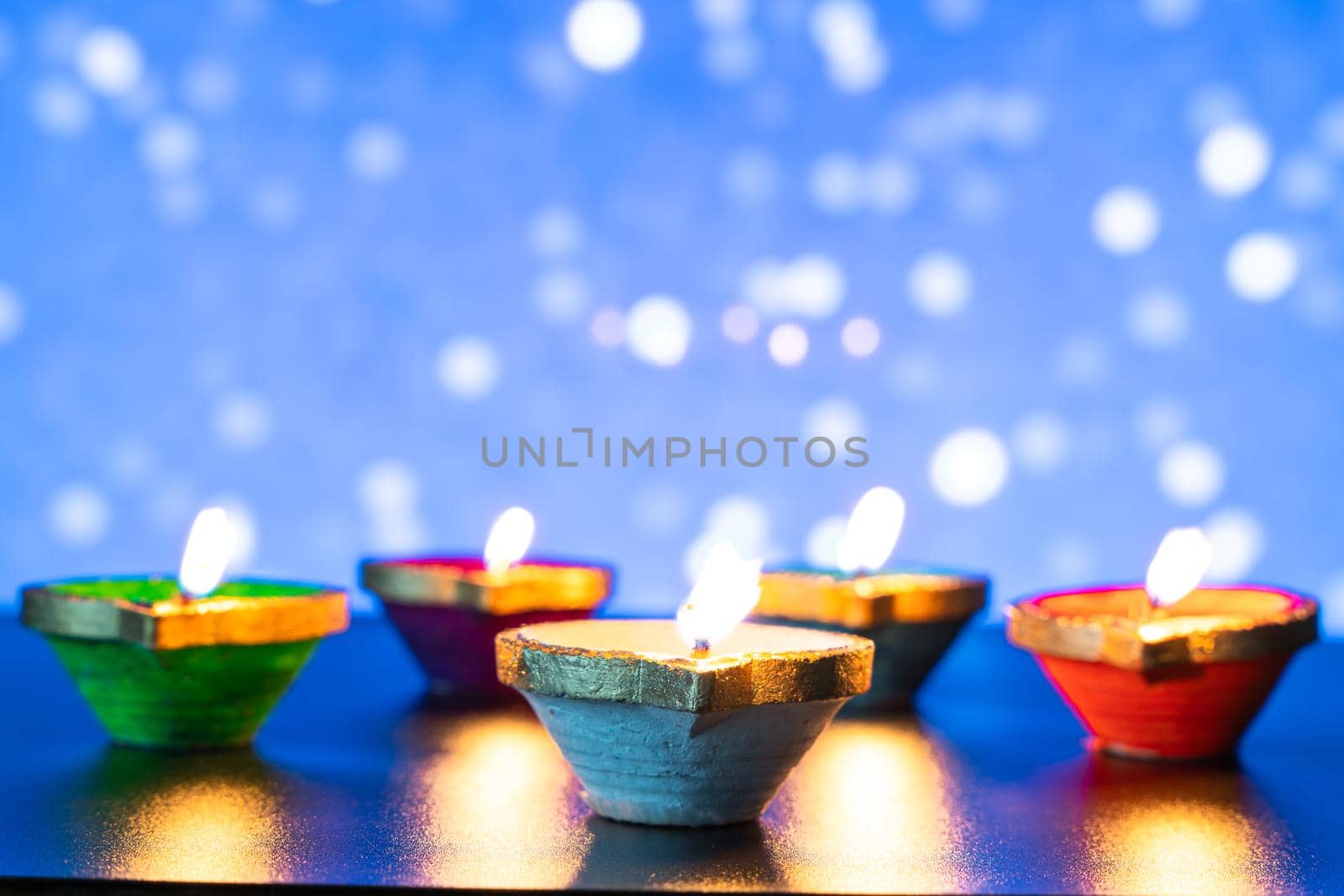 Indian festival Diwali, Diya oil lamps lit on colorful rangoli. Hindu traditional. Happy Deepavali. Copy space for text.