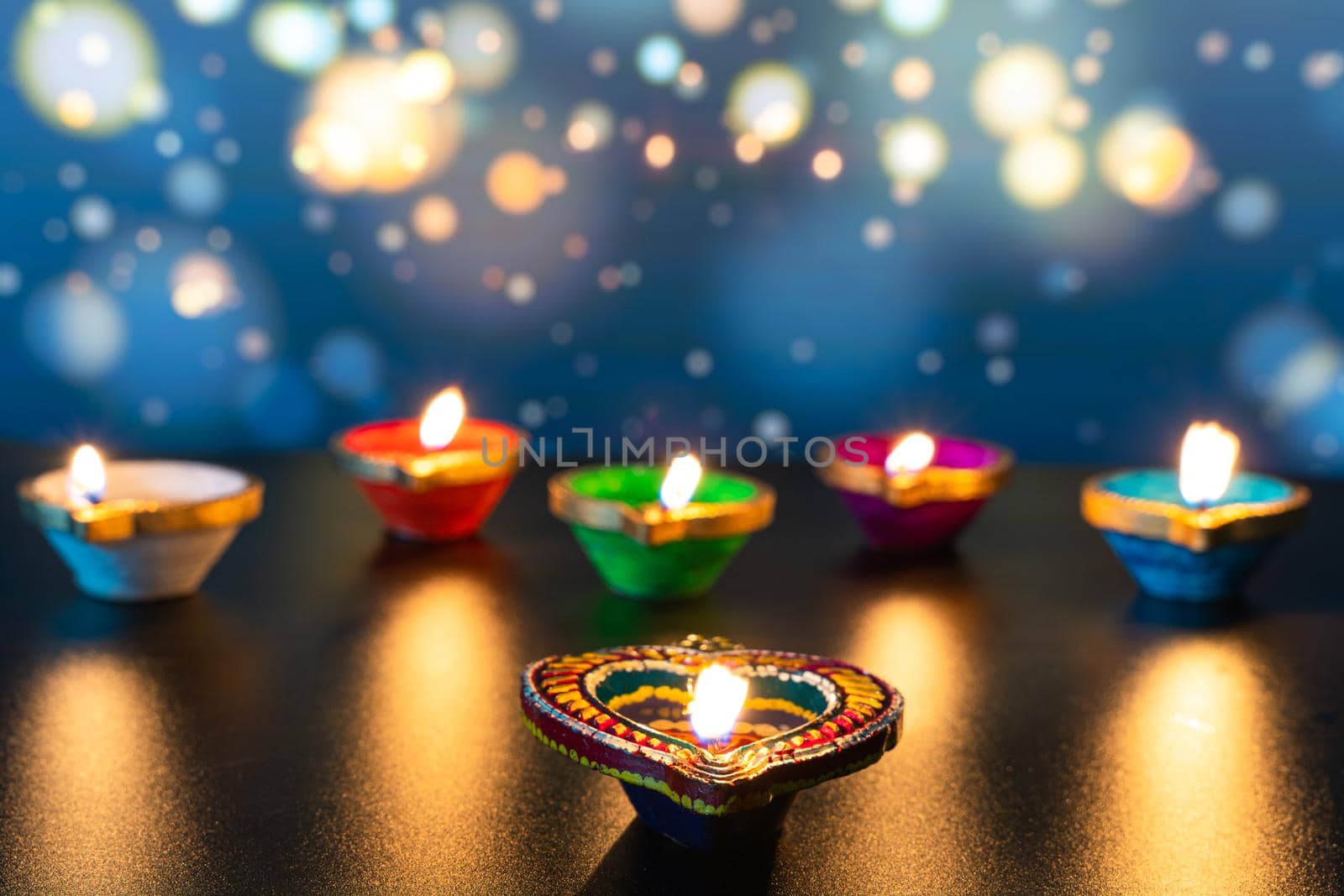 Indian festival Diwali, Diya oil lamps lit on colorful rangoli. Hindu traditional. Happy Deepavali. Copy space for text. by mikesaran