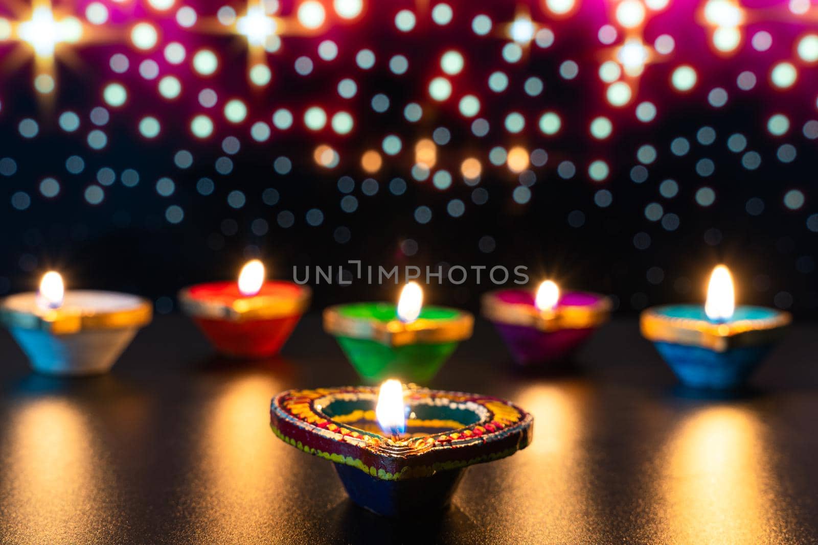 Indian festival Diwali, Diya oil lamps lit on colorful rangoli. Hindu traditional. Happy Deepavali. Copy space for text. by mikesaran