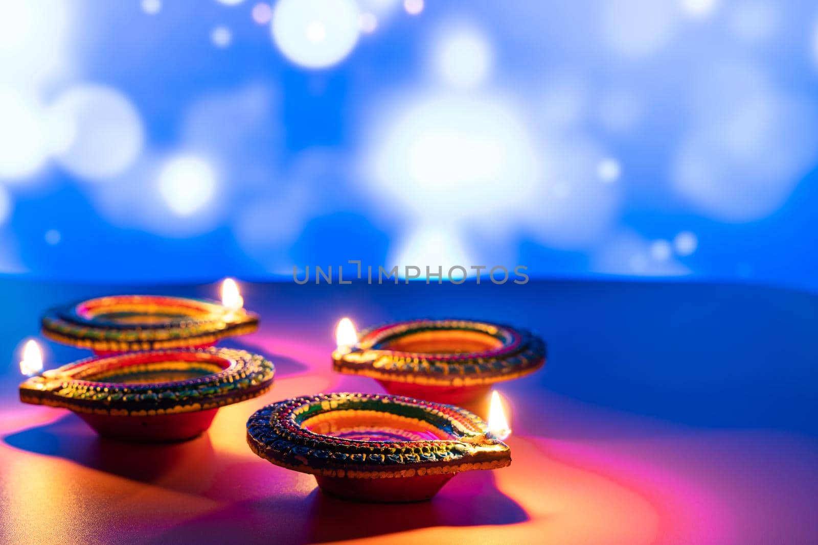 Indian festival Diwali, Diya oil lamps lit on colorful rangoli. Hindu traditional. Happy Deepavali. Copy space for text.