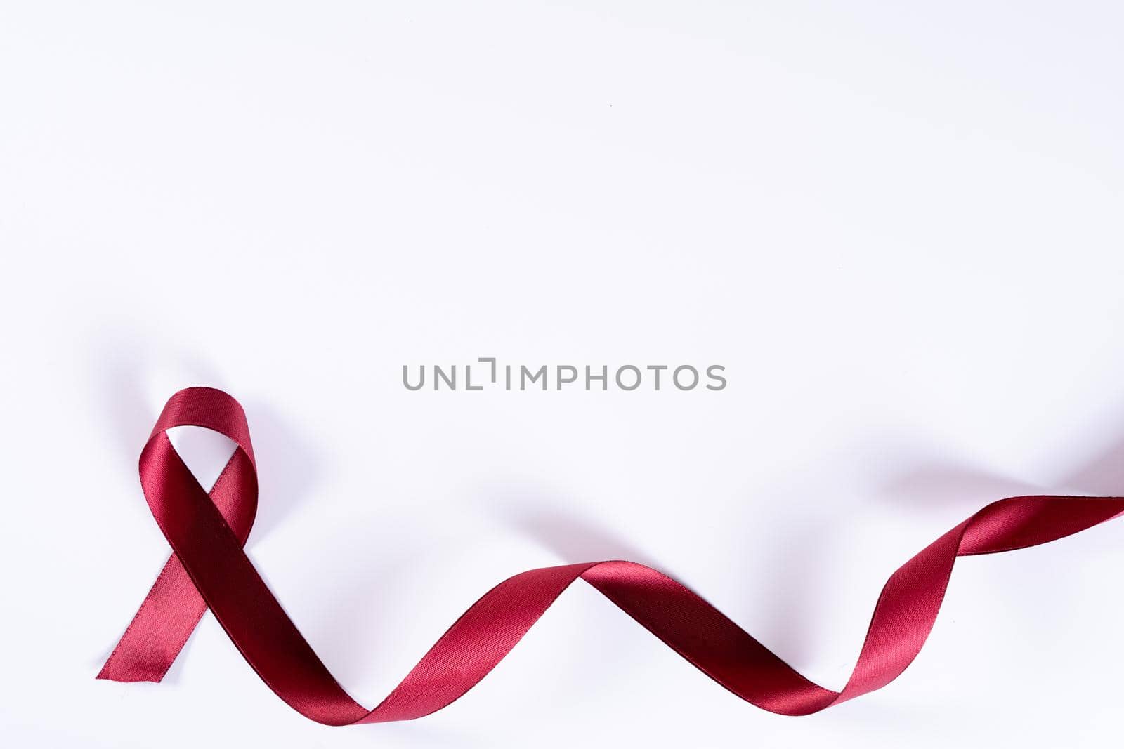 Aids awareness, red ribbon on white background with copy space for text. World Aids Day, Healthcare and medical concept.