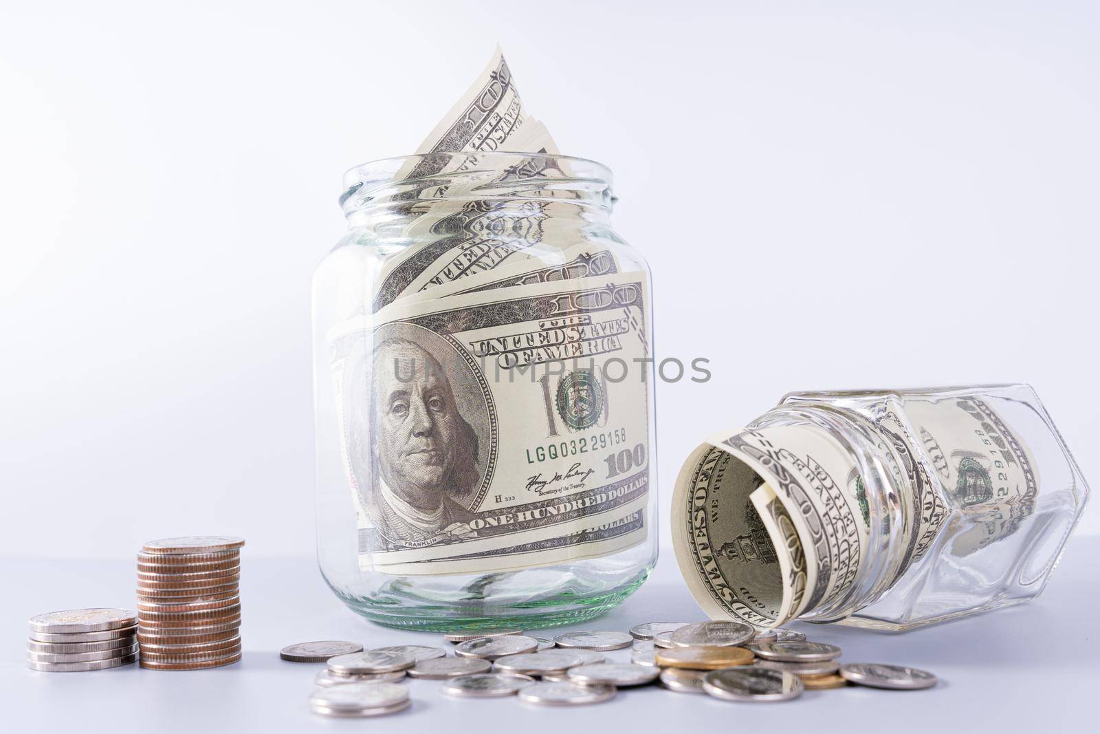 Money paper inside jar and stack coins isolated grey background. Property investment and house mortgage financial concept.