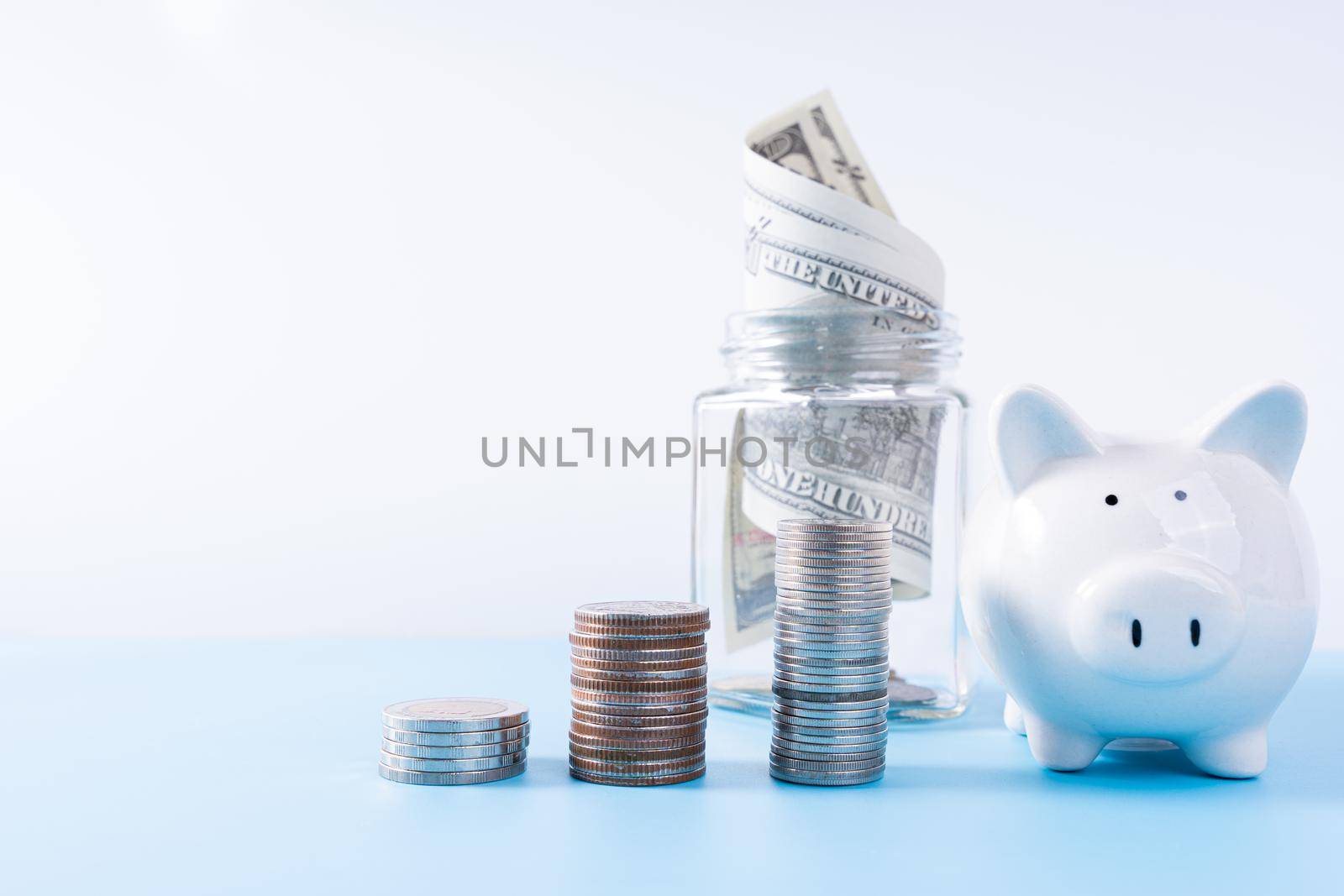 Piggy bank with stack coins and money paper inside jar isolated grey background. Property investment and house mortgage financial concept.