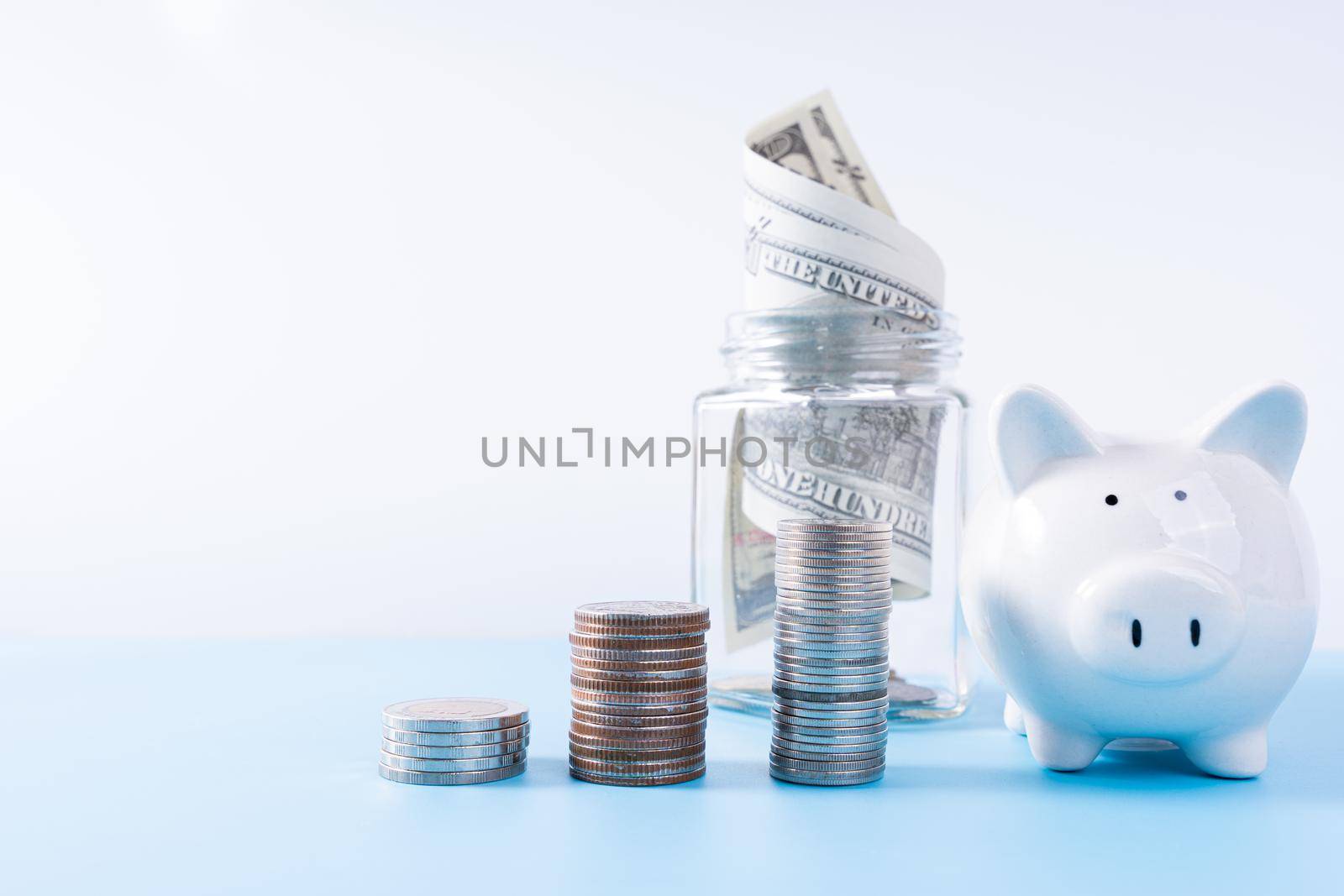 Piggy bank with stack coins and money paper inside jar isolated grey background. Property investment and house mortgage financial concept. by mikesaran