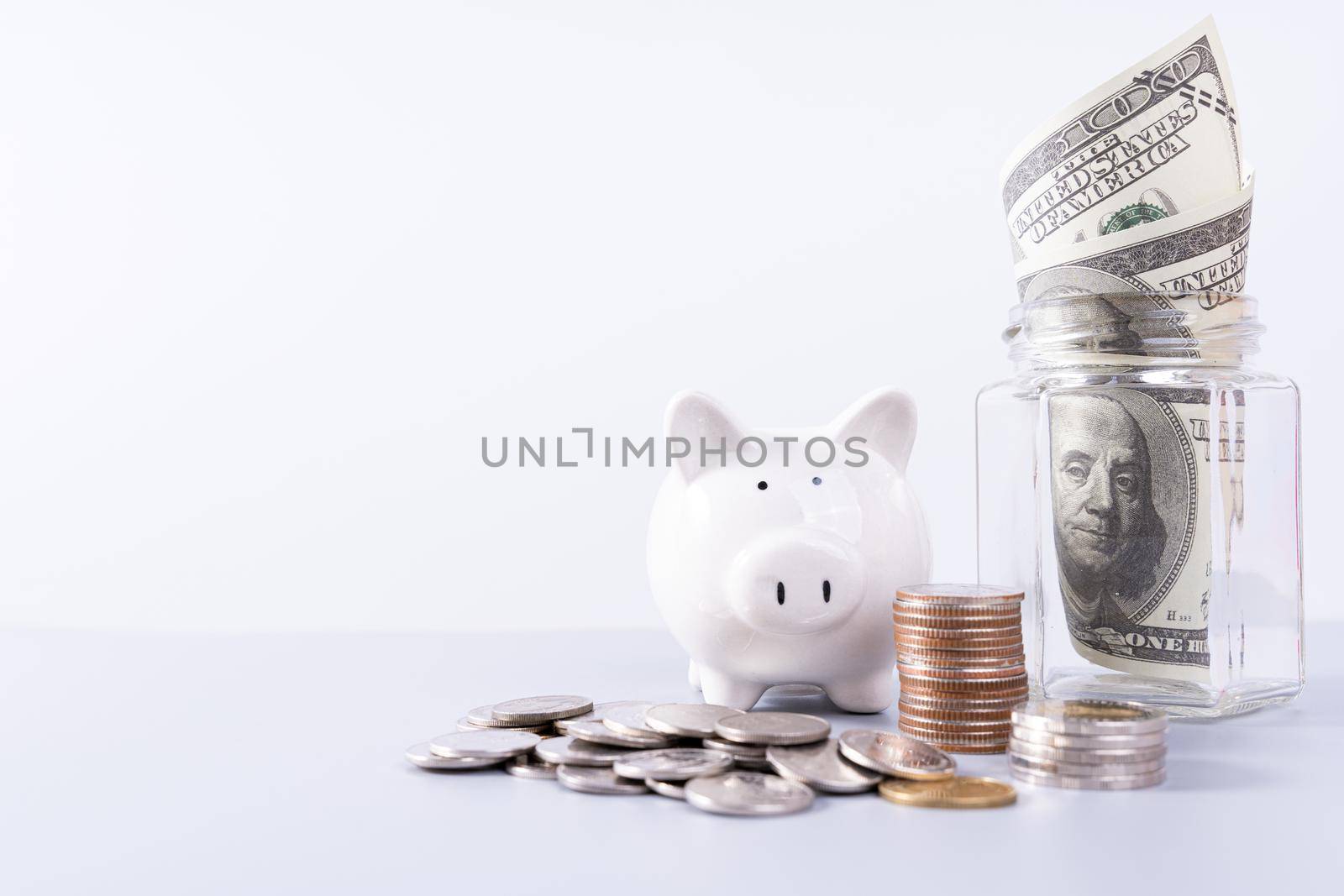 Piggy bank with stack coins and money paper inside jar isolated grey background. Property investment and house mortgage financial concept. by mikesaran