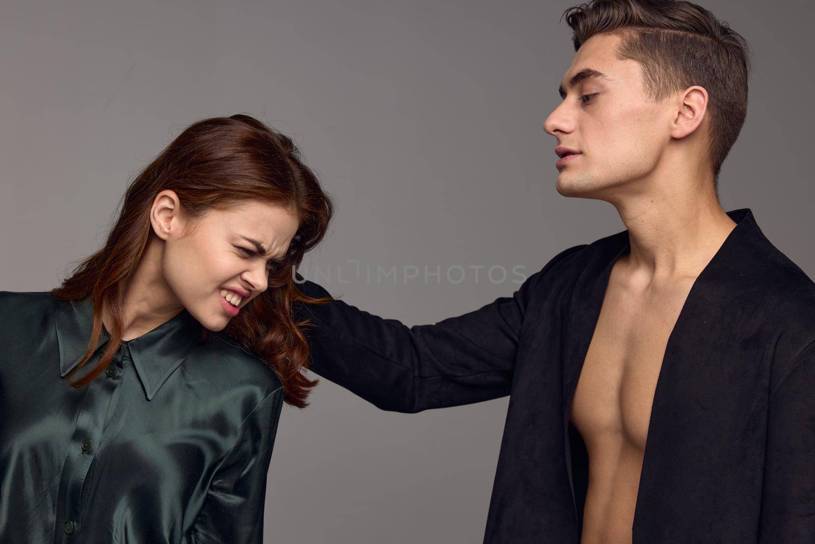 Man hurting beautiful woman on gray background aggression distrust stress by SHOTPRIME