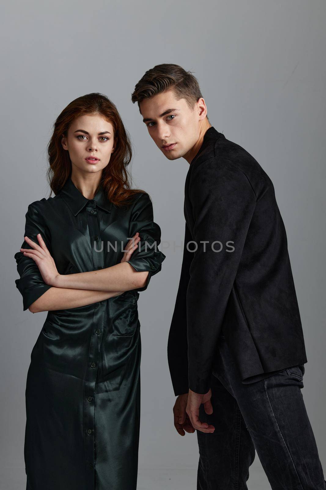 Fashionable man and attractive woman on gray background couple in love portrait by SHOTPRIME