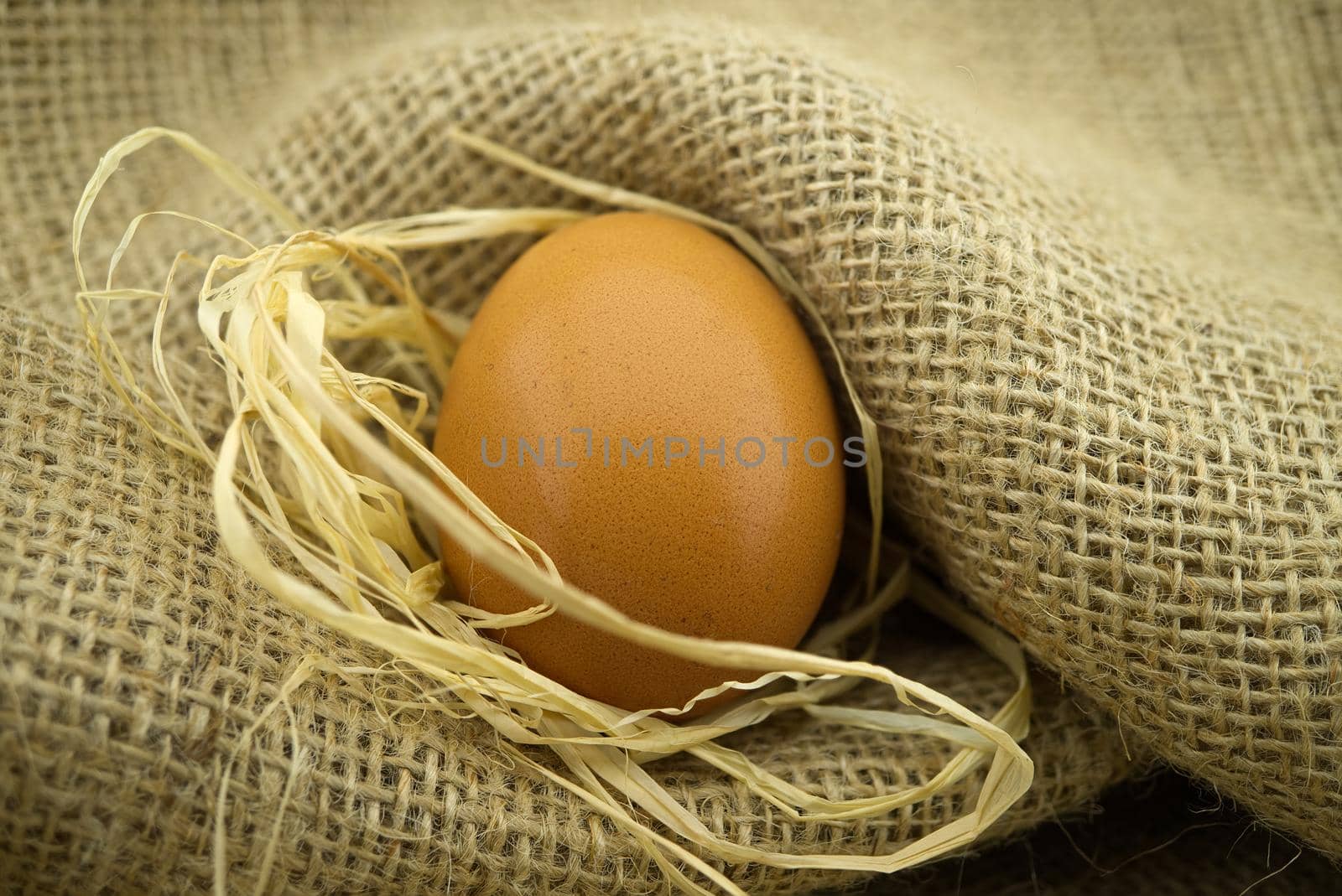 Brown raw chicken eggs on sack cloth fabric. Organic farming background with copy space
