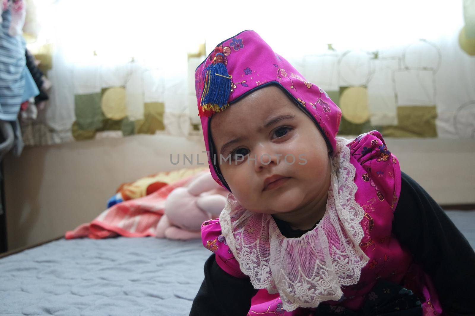 Baby girl with lovely face, big eyes and cute face gesture. Toddler baby making sweet activities