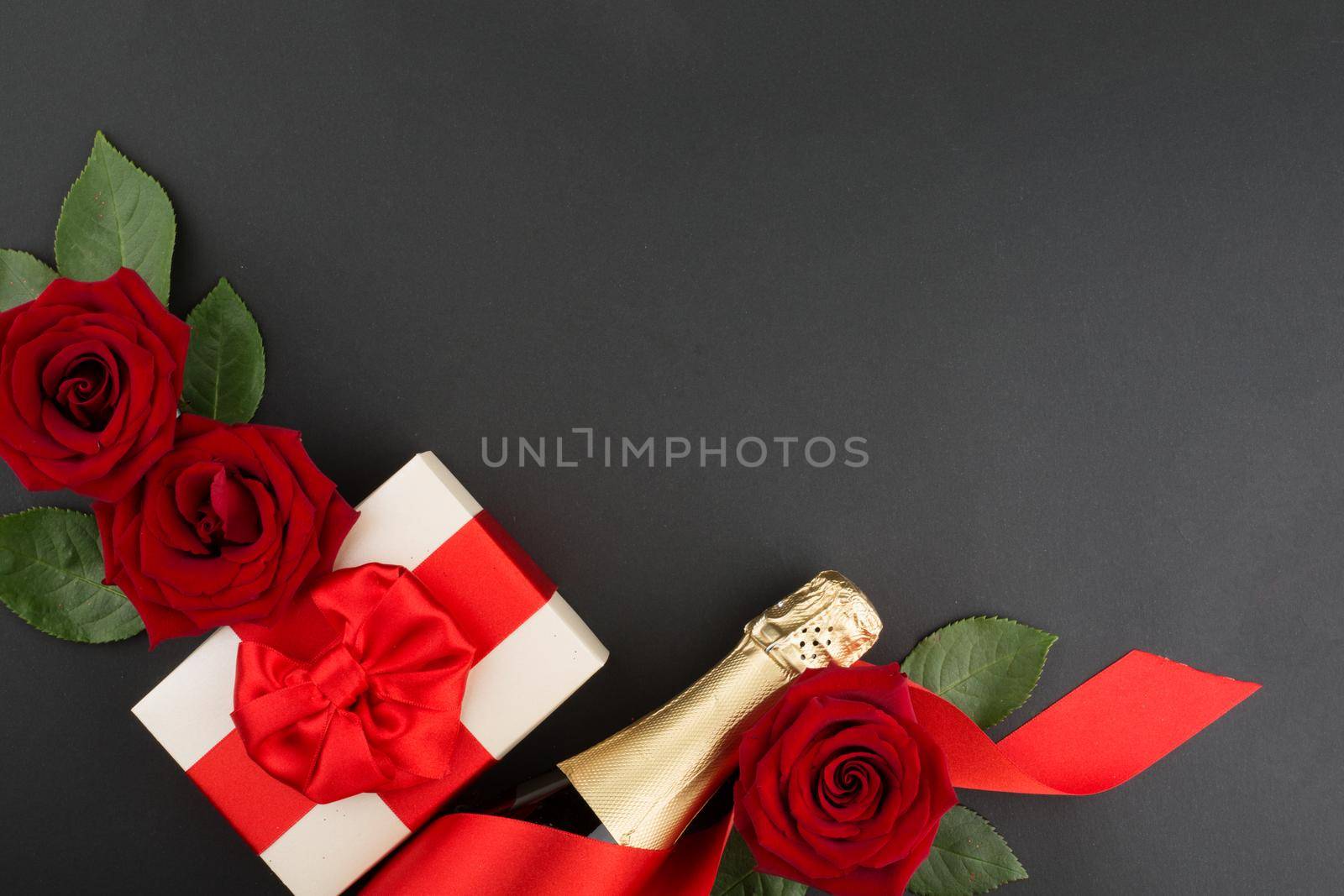 Valentines day composition flat lay top view with gift box rose flowers gift champagne design element on black background with copy space for text