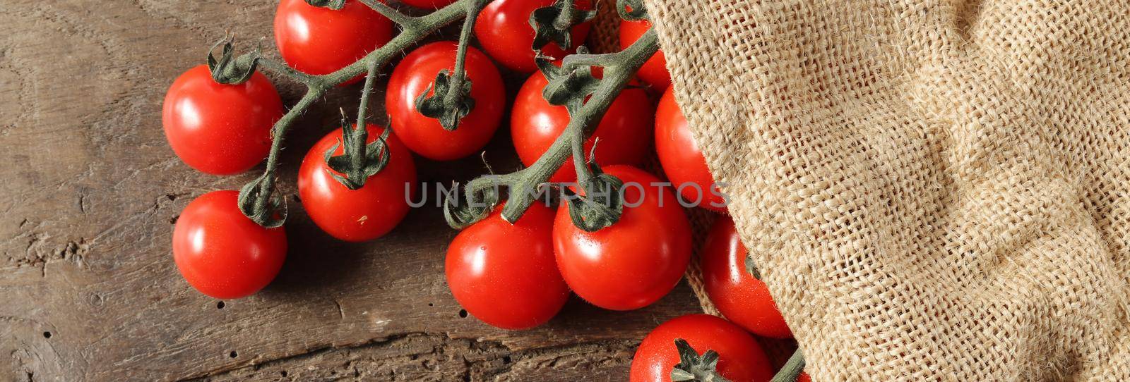 Rustic background with tomatoes, canvas bag on old wooden background. Rustic kitchen with tomatoes