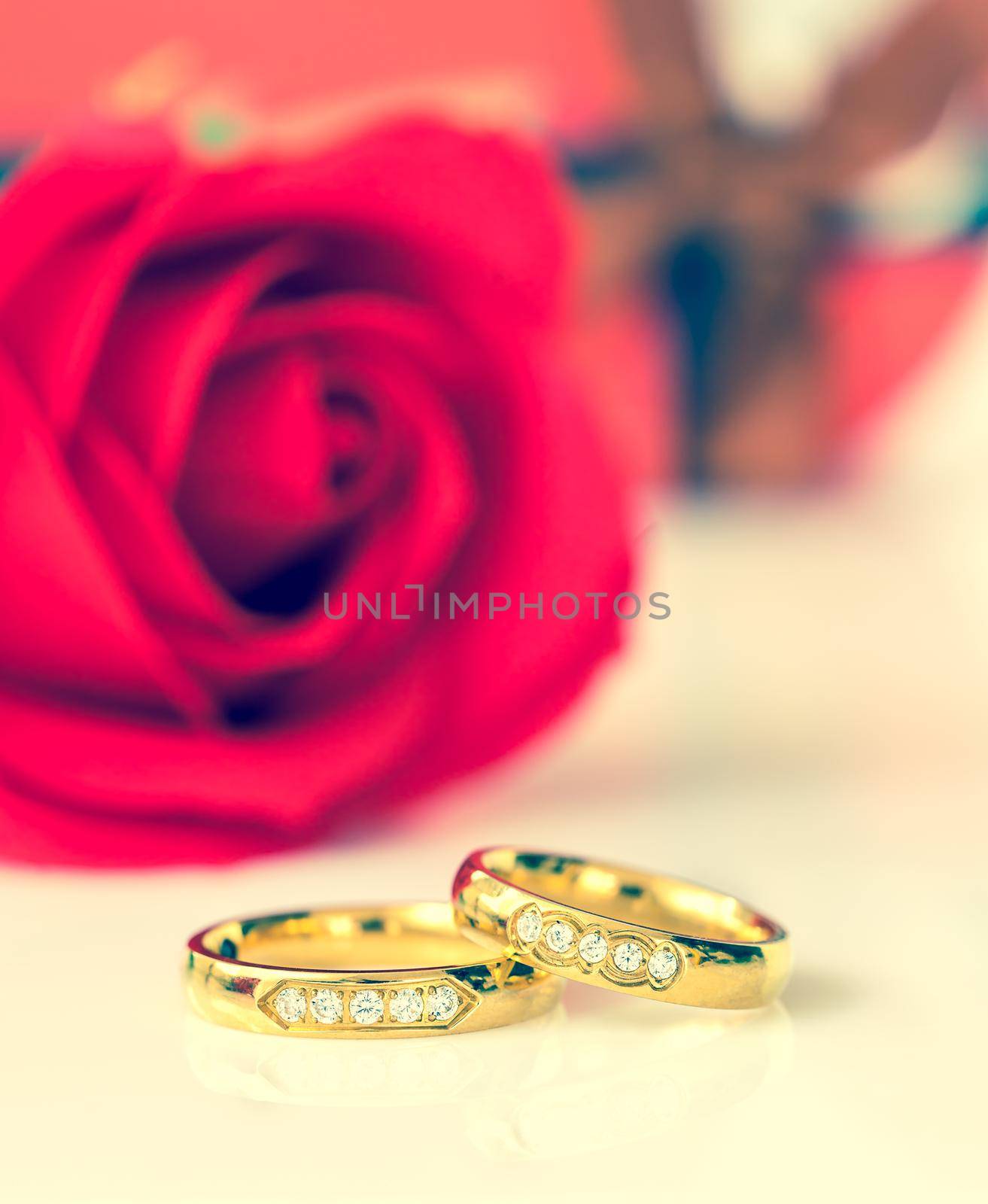 Red plastic fake roses, Wedding concept with roses and gold rings