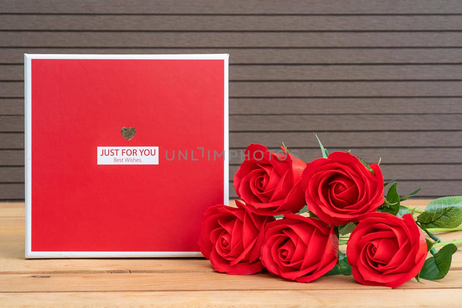 Love concept, Red roses with gift-box on wood table