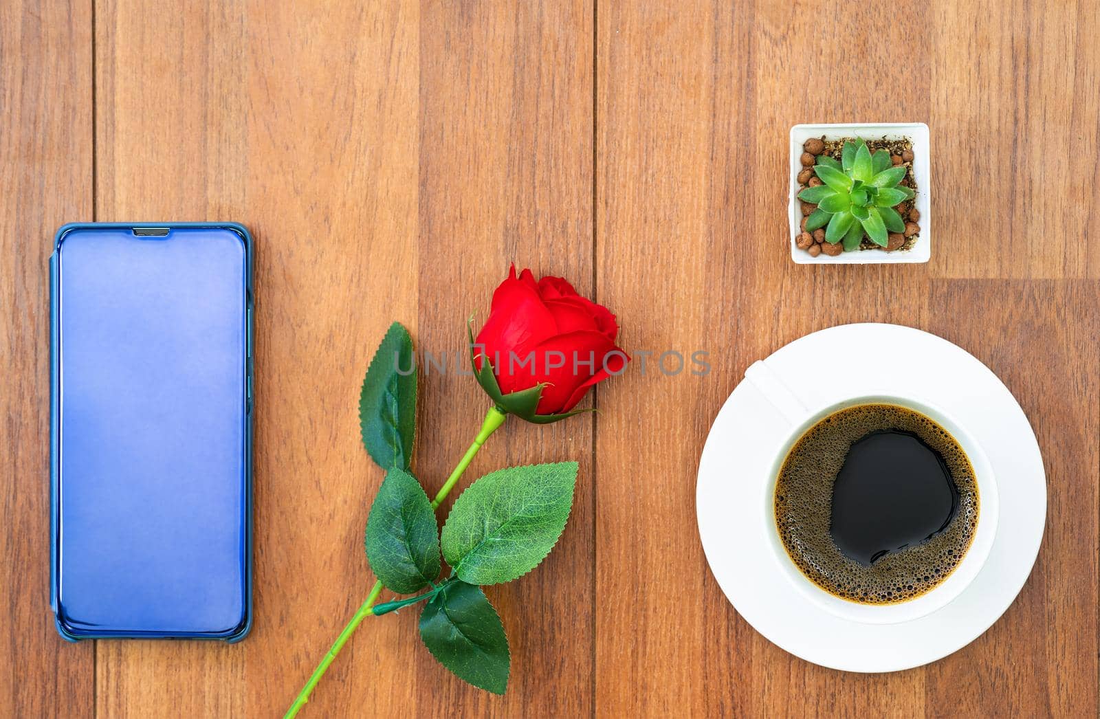 Top view white cup of coffee and red rose with cellphone on wood background valentine concept