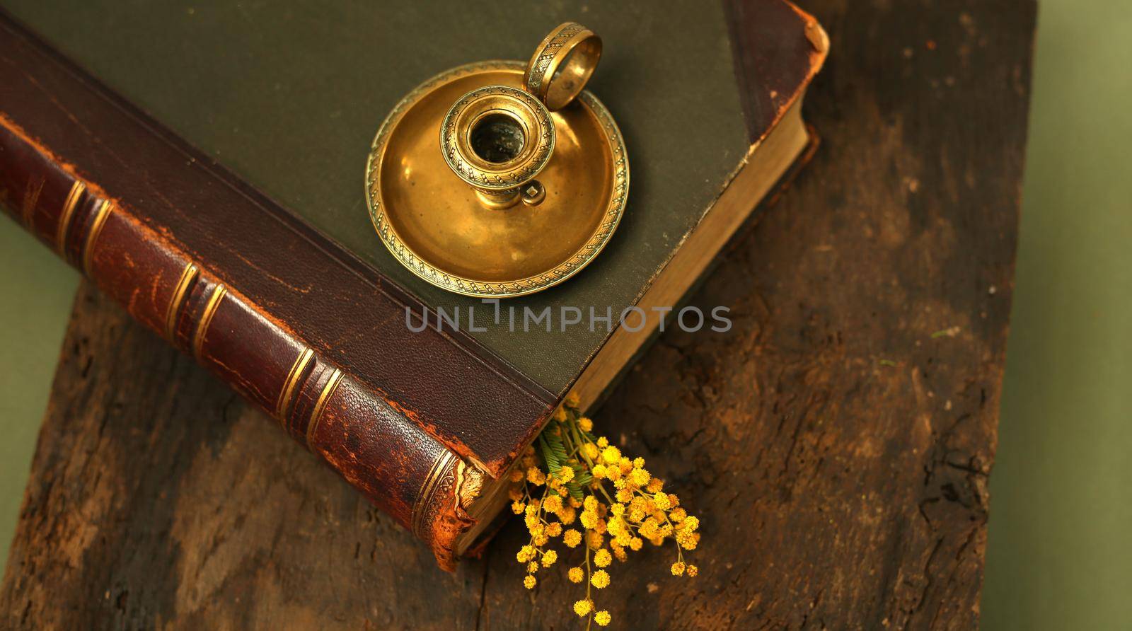 Old antique book with candlestick candle holder on old wood background. Memory, past, family album concept