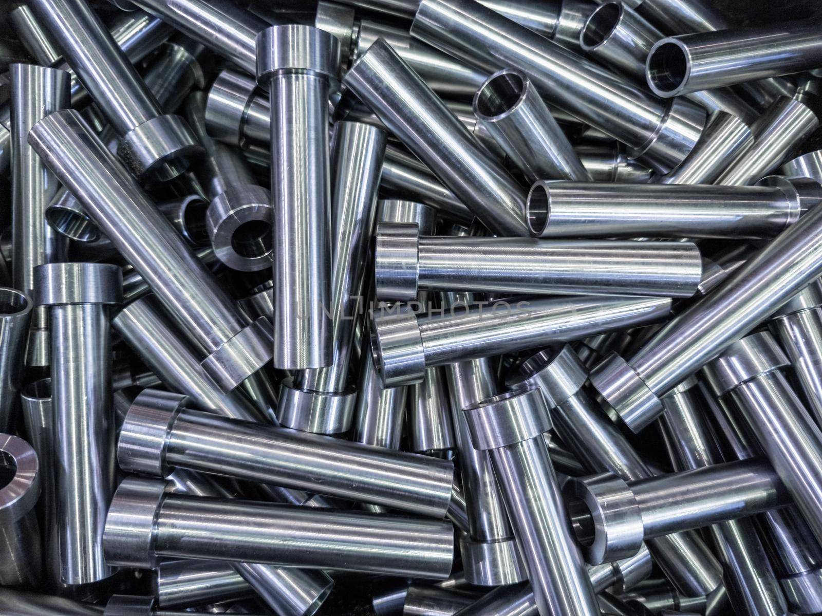 full frame abstract indistrial background of pile of shiny steel tubes after cnc turning operations