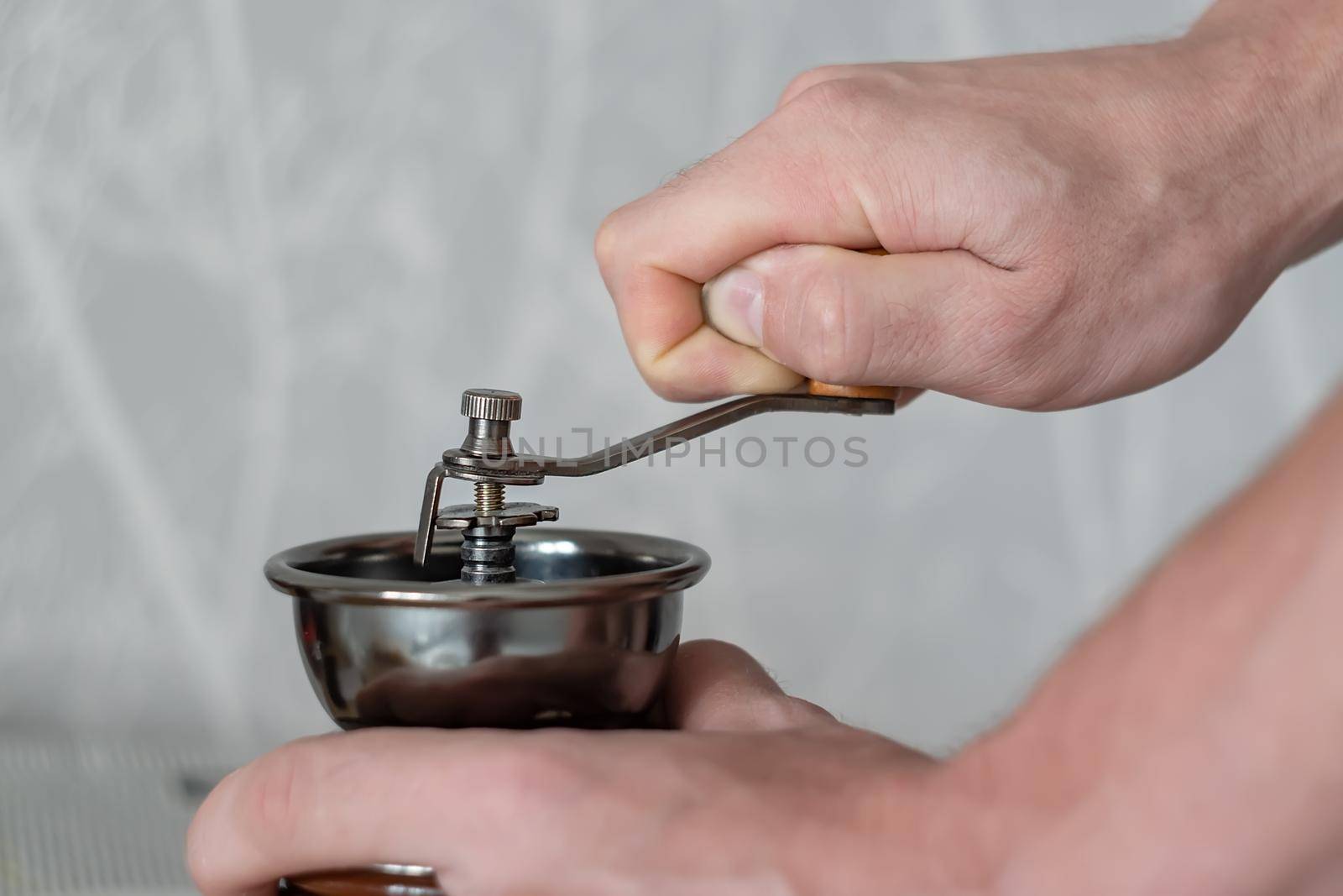 mechanical machine for grinding coffee beans in the hands of a person by jk3030