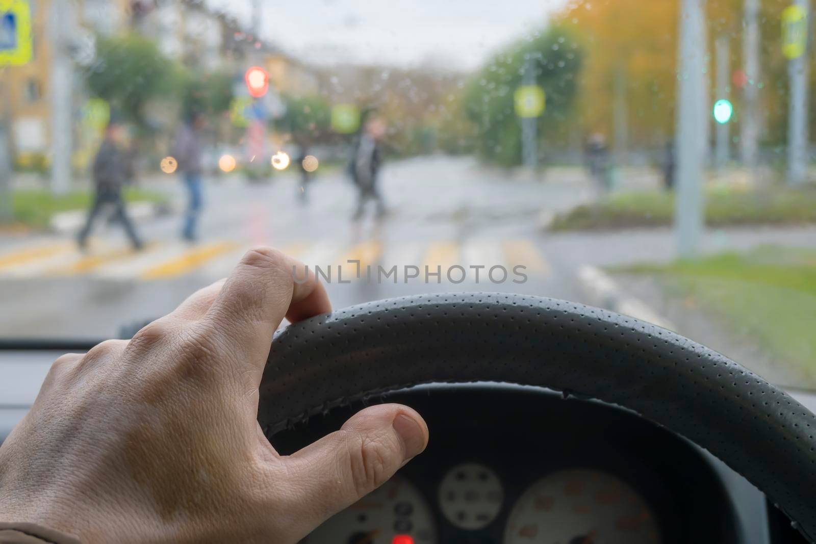 driver's hand on the steering wheel of the car in cloudy weather by jk3030