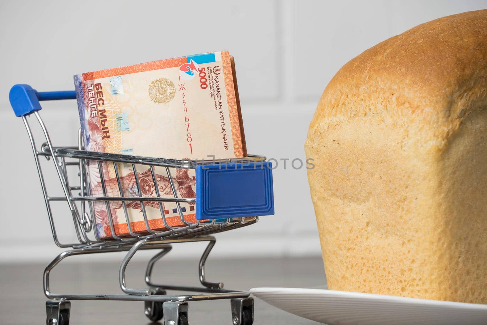 Kazakhstan tenge KZT in a grocery basket with bread. Rising food prices and groceries in Kazakhstan and other countries. Humanitarian assistance.