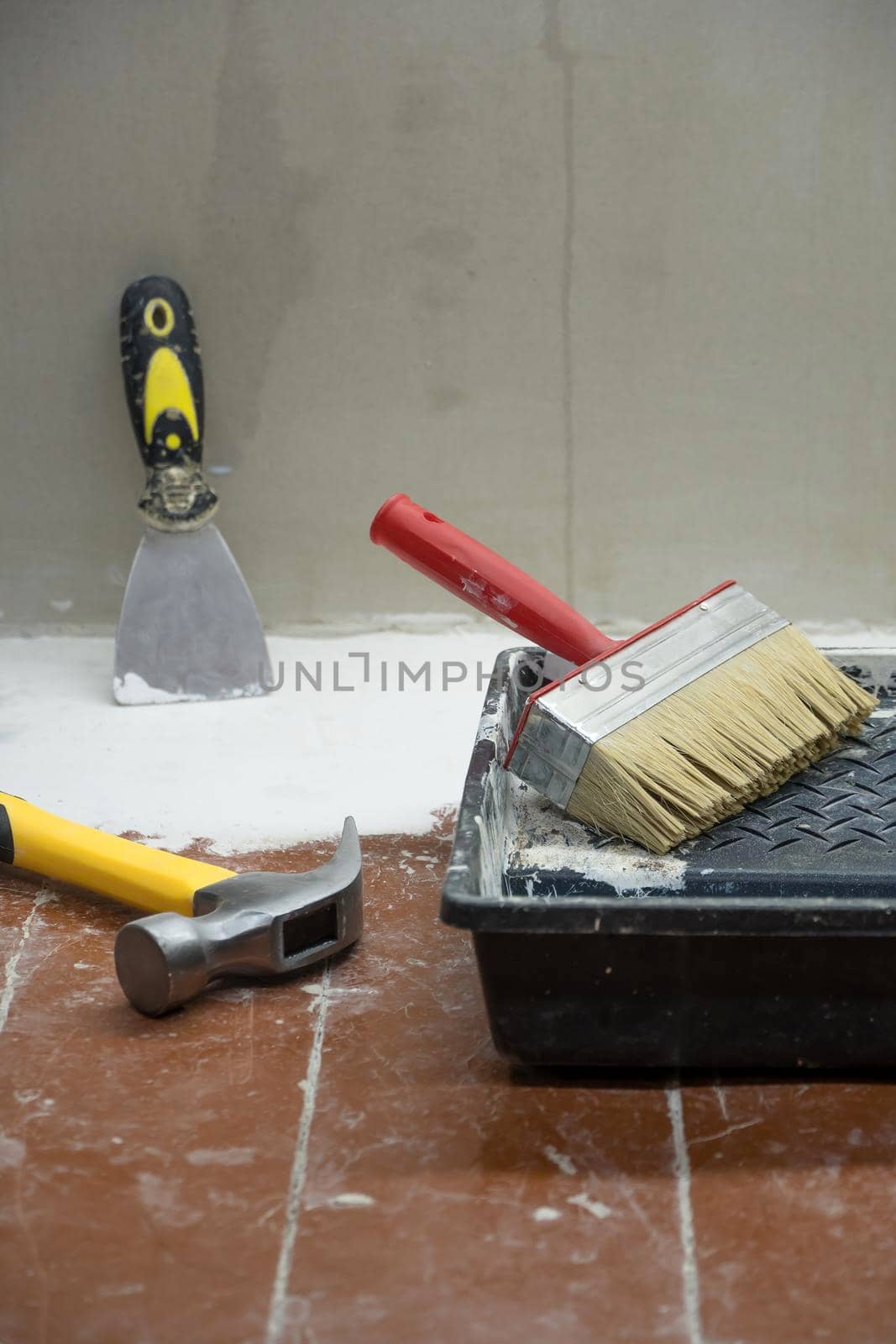 Construction and painting tools lie on the floor during the repair and restoration of the house.Work as a Builder or handyman in the house.Finishing or repairing a room.Job of repairing the apartment by YevgeniySam