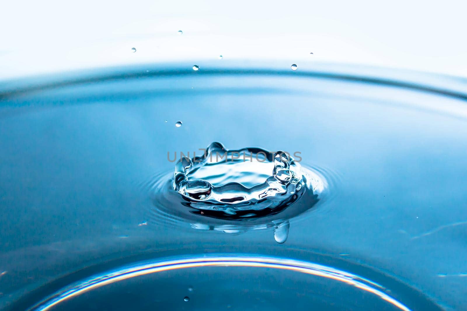 Water splash backgrounds close-up.Crown of blue water.Water drop.Frozen splashing in motion.Slow dripping of liquid with air bubbles. Nature backgrounds or Wallpaper.Frozen liquid splashes