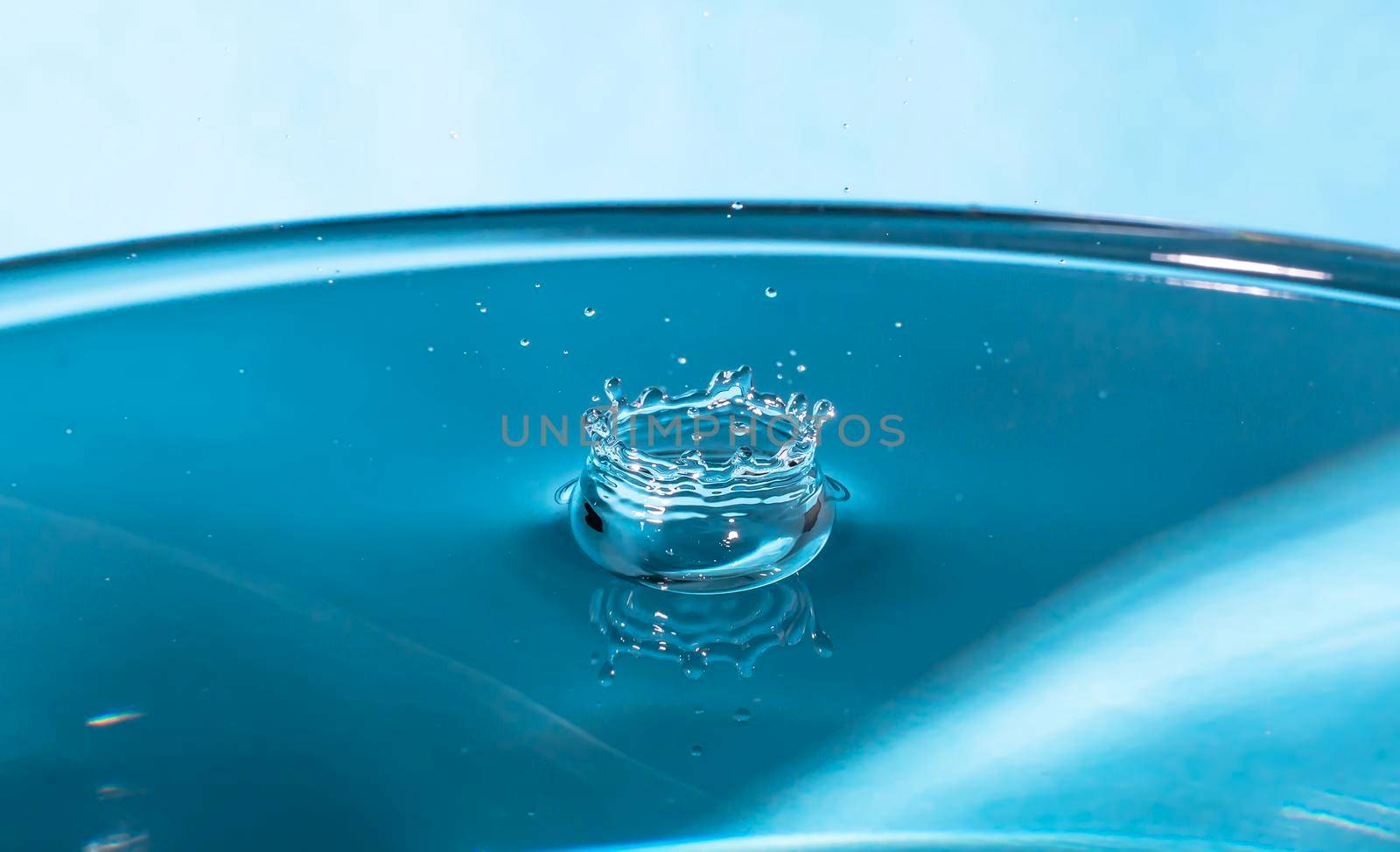 Abstract an outbreak of water. Splash of water close-up. Frozen water drop photographed at high speed.Slow dripping of liquid with air bubbles. Nature backgrounds or Wallpaper.Frozen liquid splashes by YevgeniySam