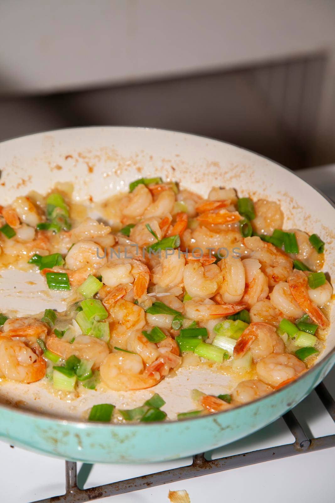 Cooking shrimp and green onion in a frying pan