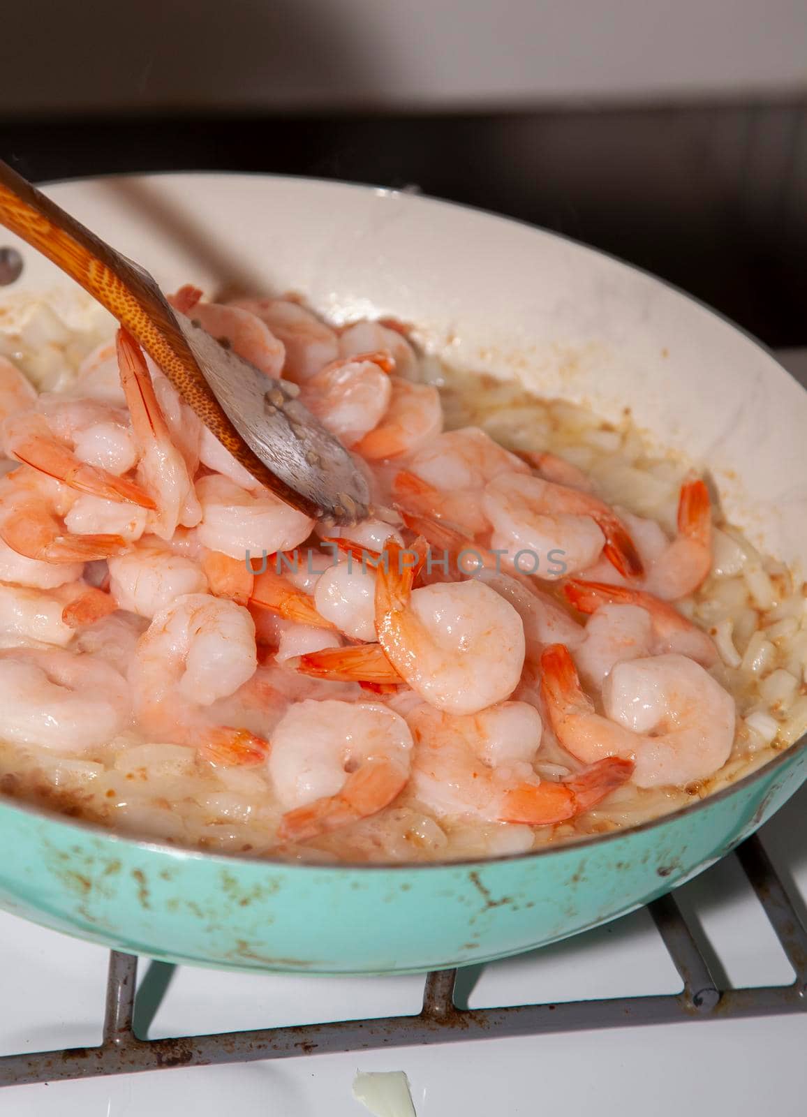 A pound of raw, thawed shrimp in a frying pan