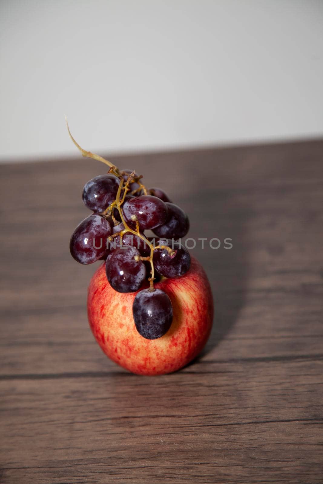 Washington apple and red seedless grapes on a wooden table