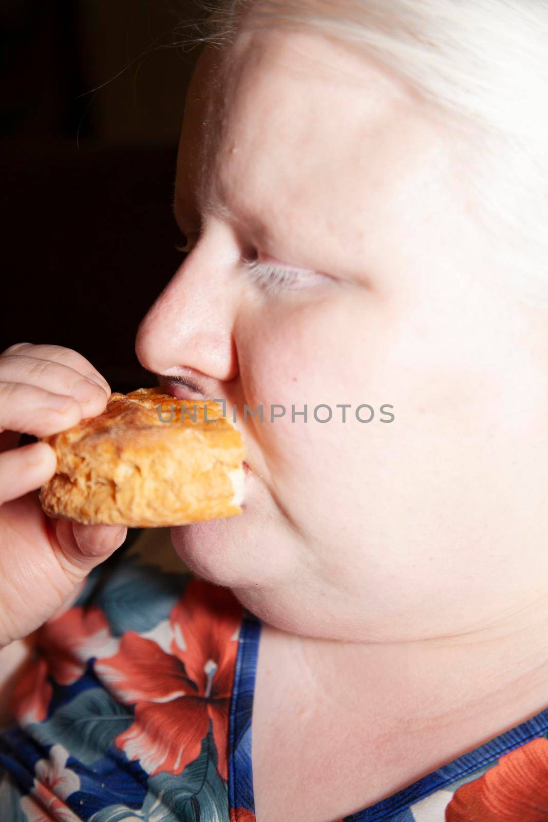 Close up of an albino woman eating a buttermilk biscuit