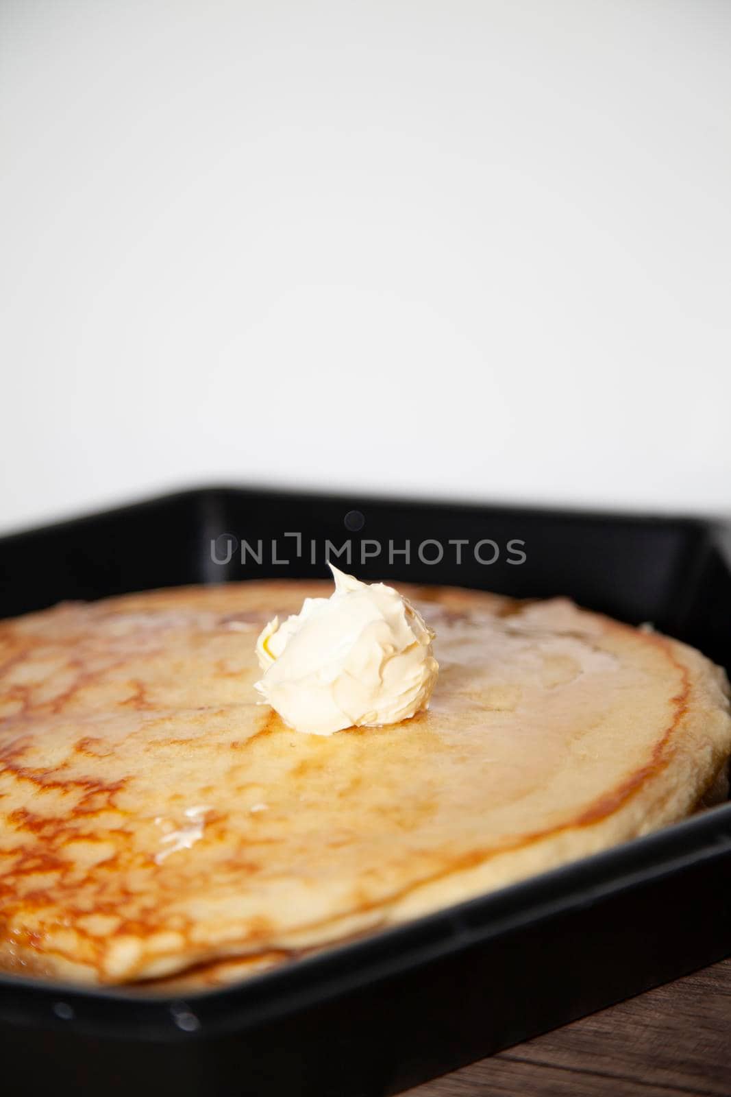 Two plain pancakes with butter and light syrup