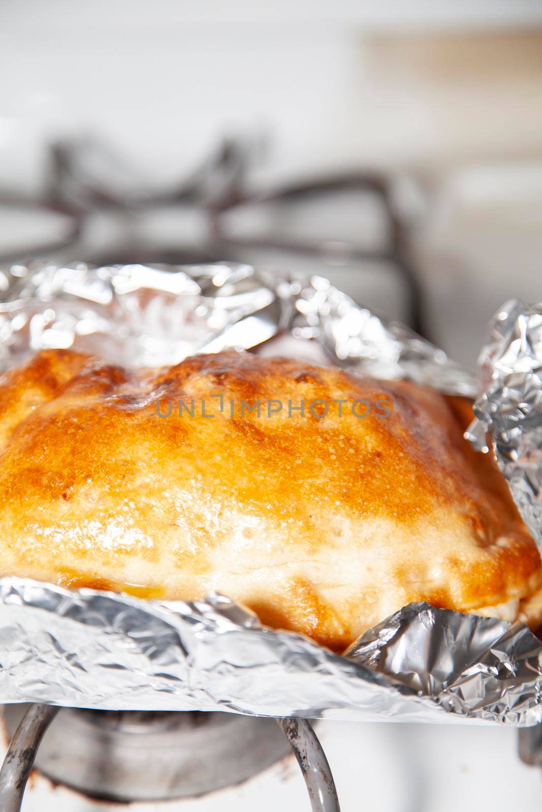 Glazed outter bread of a fresh calzone on foil