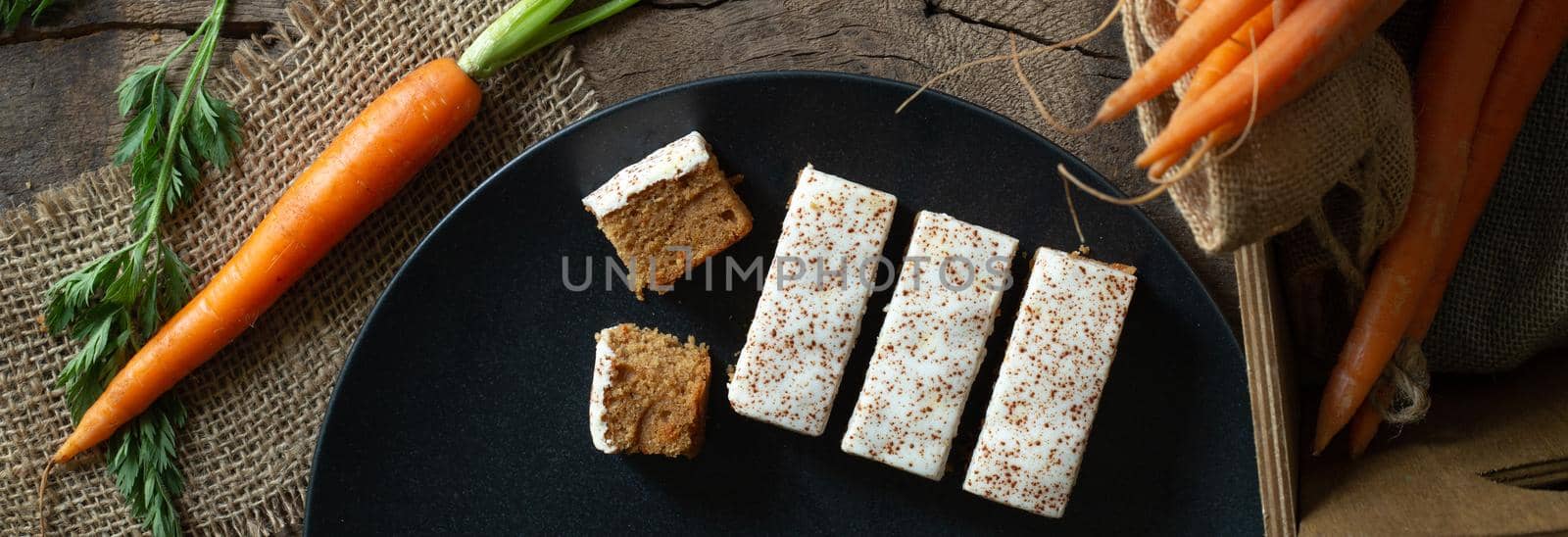 carrot cakes with fresh bunch of carrots on rustic kitchen top. Horizontal flat lay top view