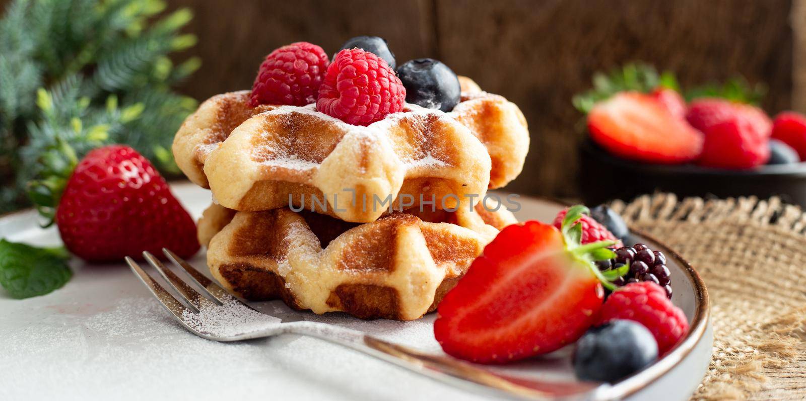 Summer health breakfast with fruits Belgian waffles on canvas. Rustic kitchen with fresh strawberries, summer breakfast with fruits