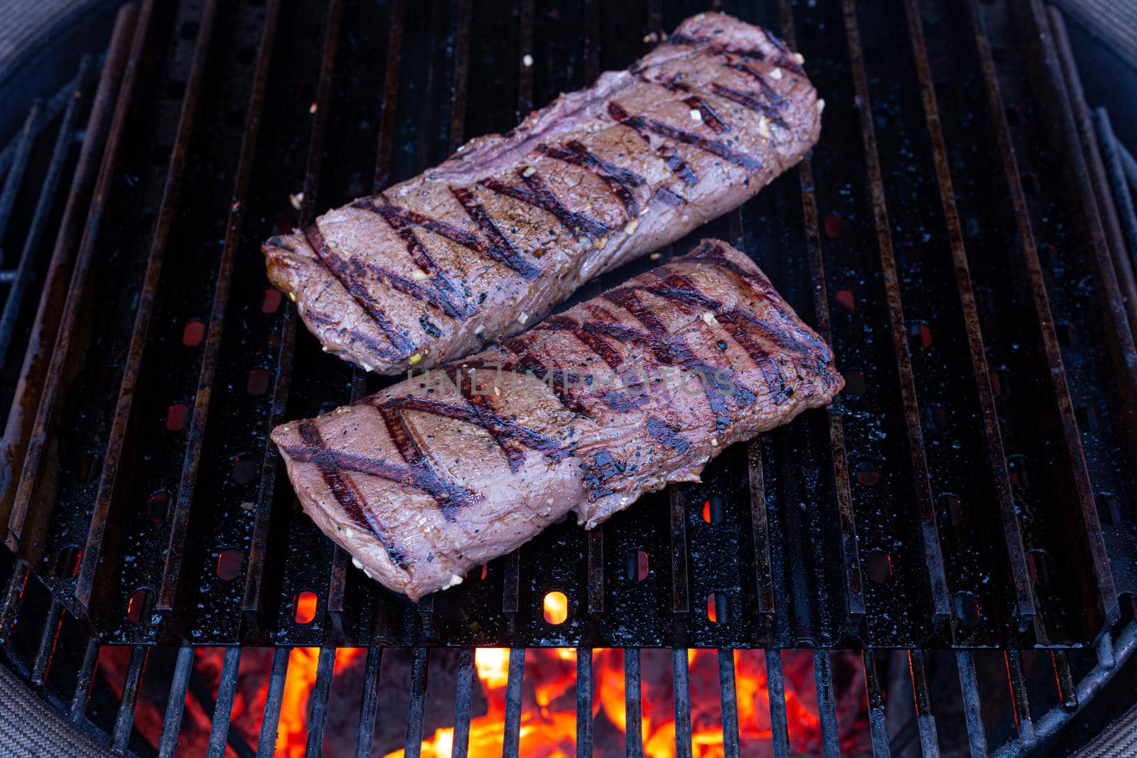 Venison steak on the grill with fire beneath