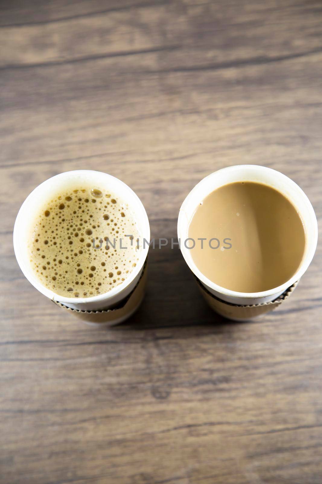 Macchiato and latte in carry out cups on a wooden table