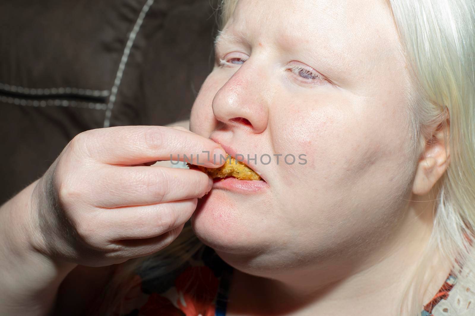 Obese, albino woman enjoying eating fried pickle slices