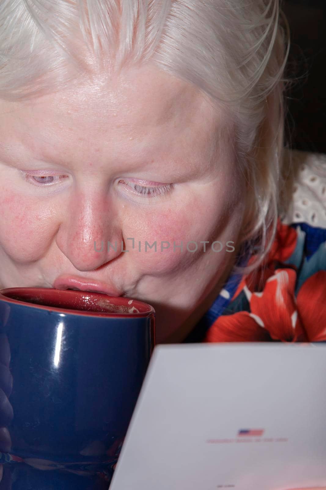 Woman reading a Christmas card and drinking hot cocoa