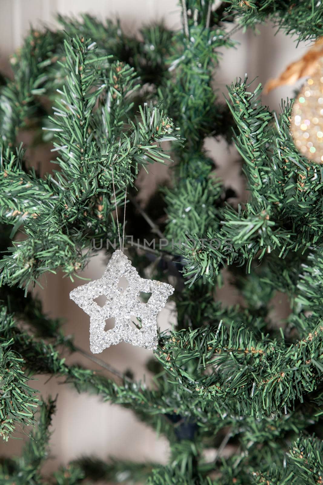 Clear, star-shaped holiday ornament on an artificial Christmas tree