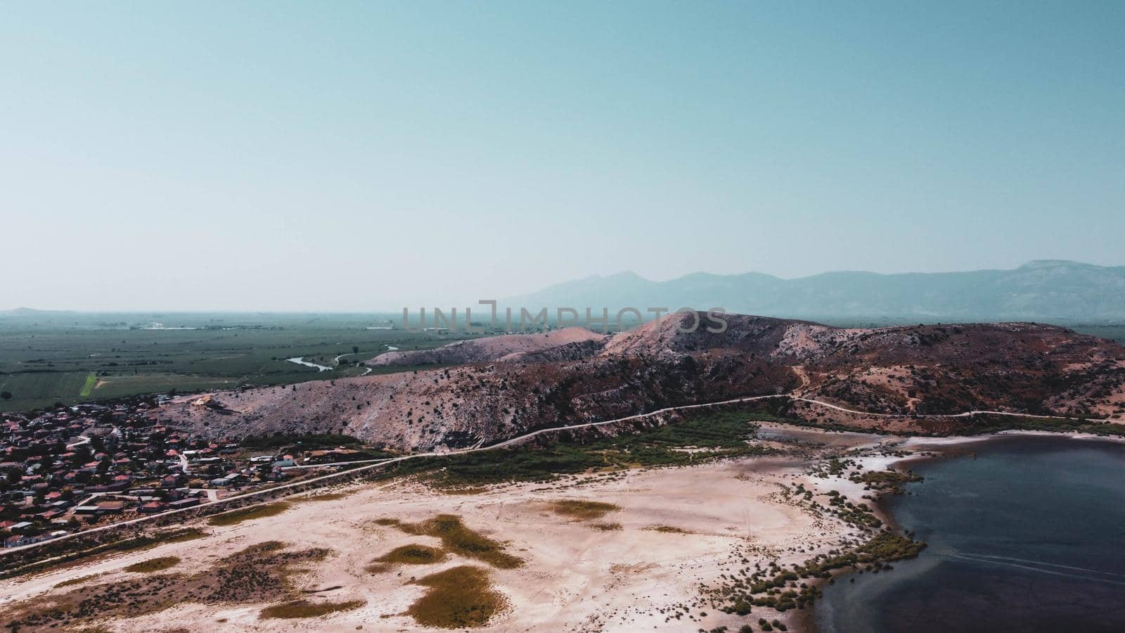 a balanced horizontal landscape drone shoot with vivid colors - there is lake and blue sky by Swonie