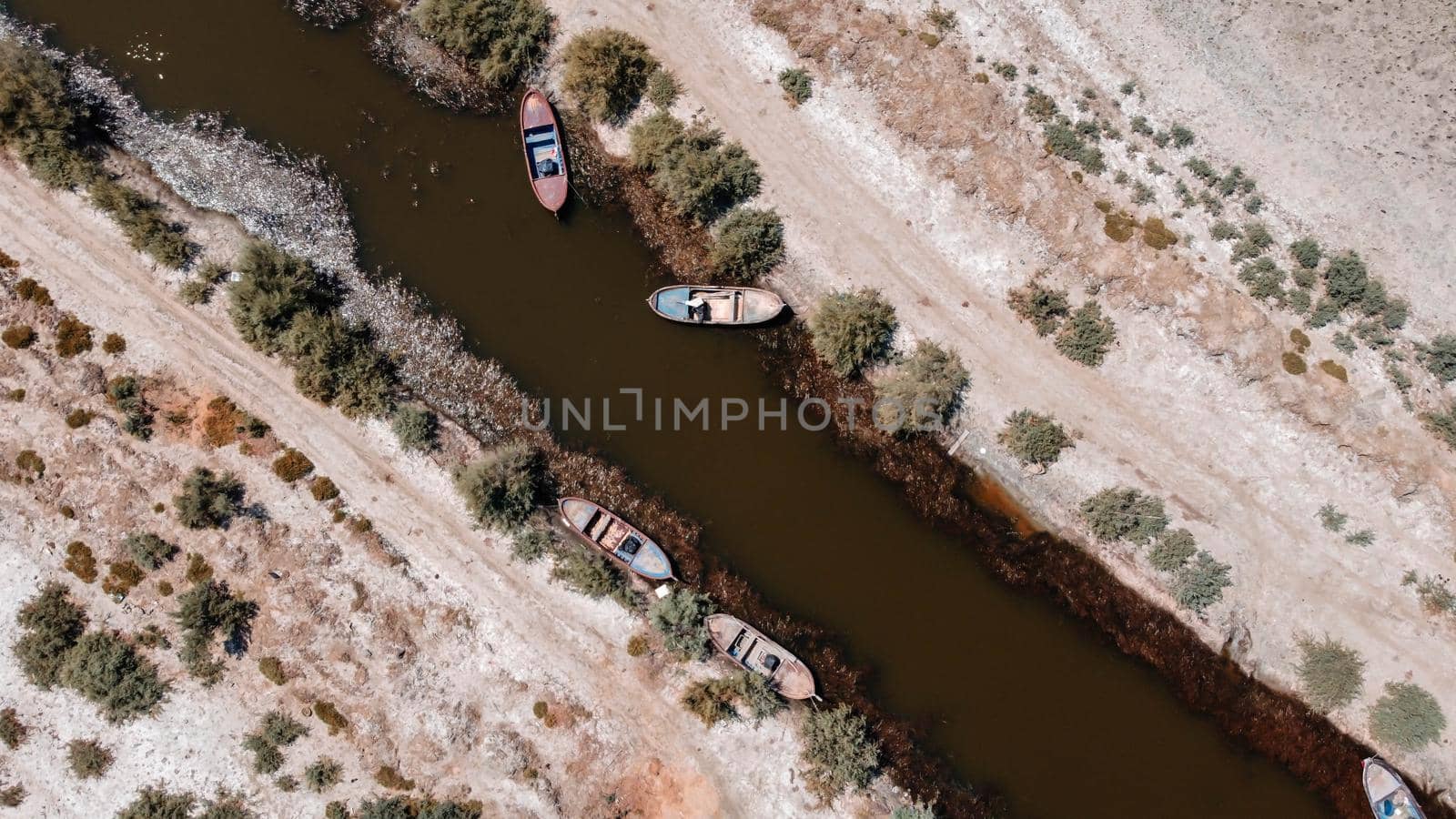 birds eye close drone shoot from a connection of lake - there is wooden boat over there red color is dominant by Swonie