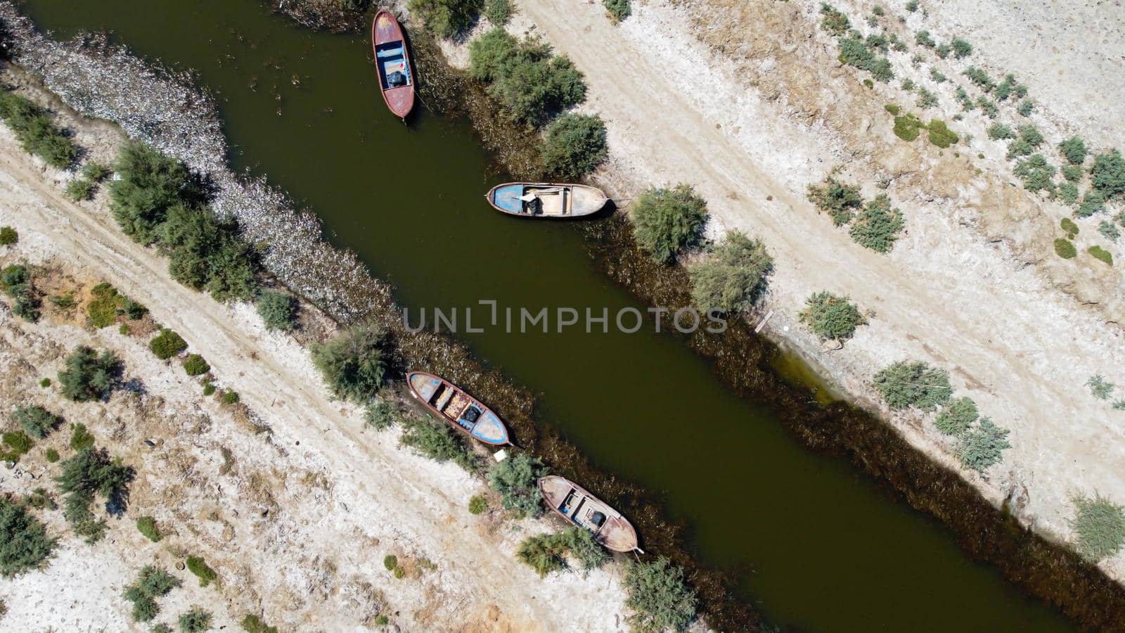 birds eye close drone shoot from a connection of lake - there is wooden boat over there. photo has taken at bafa lake in turkey.