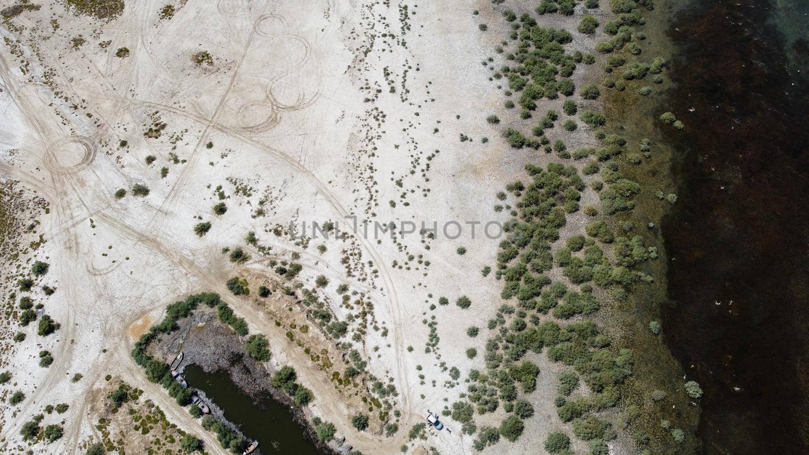 birds eye far drone shoot from a connection of lake - there is wooden boat over there green color is dominant. photo has taken at bafa lake in turkey.