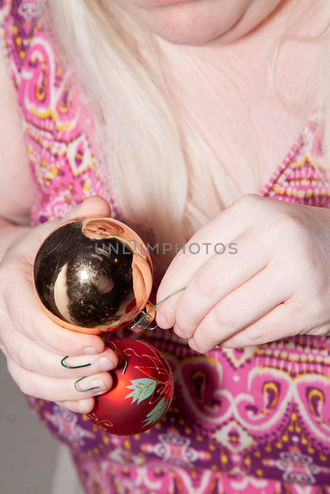 Woman preparing to hang gold and red and silver globes