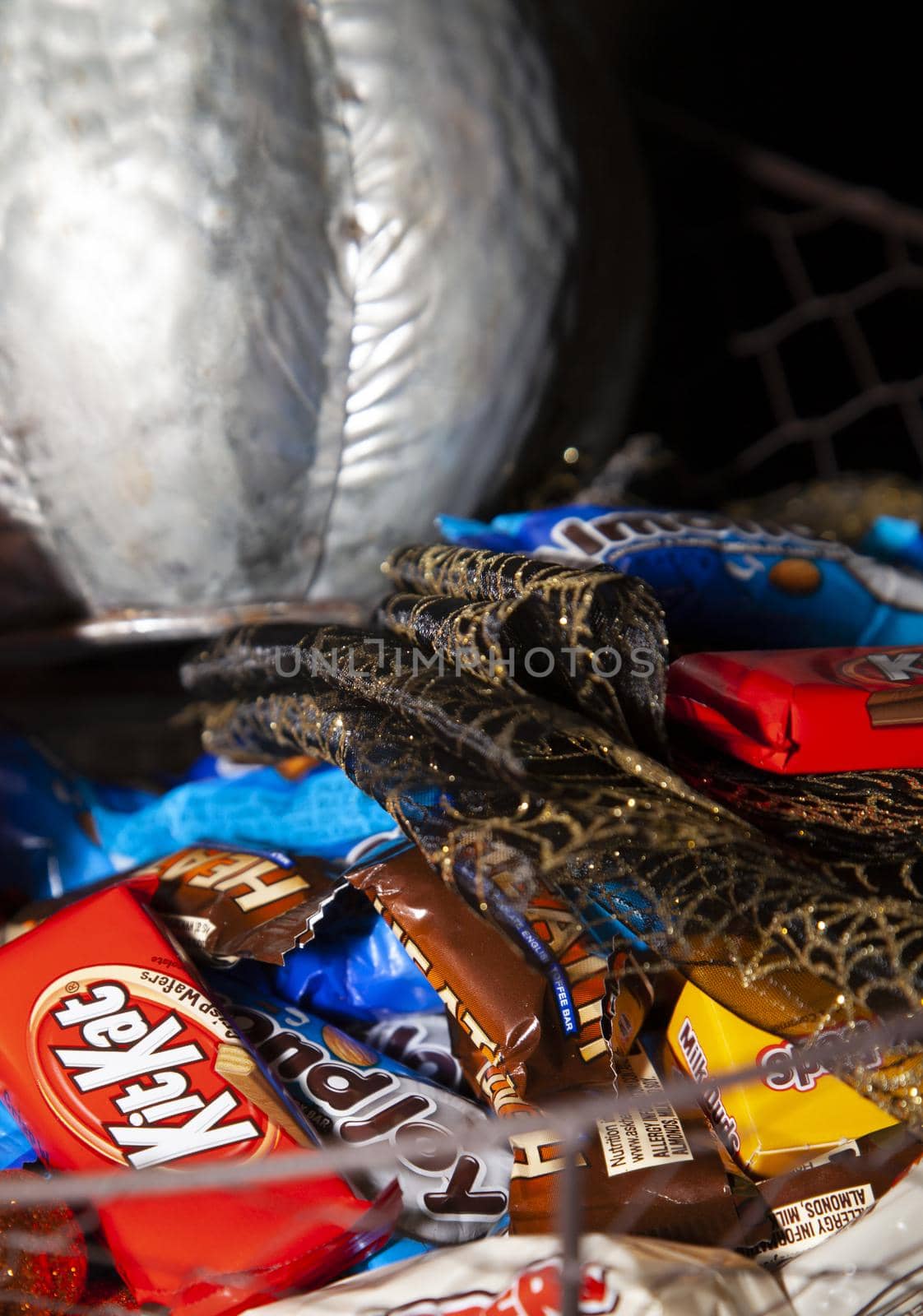 LOUISIANA/USA – OCTOBER 31 2019: Silver pumpkin, orange pumpkin, small sequined pumpkins, black and gold mesh decoration, with Reese's, Heath Bars, Milk Duds, Kit Kat, Whoppers, Almond Joy, and Baby Ruth candies to hand out.