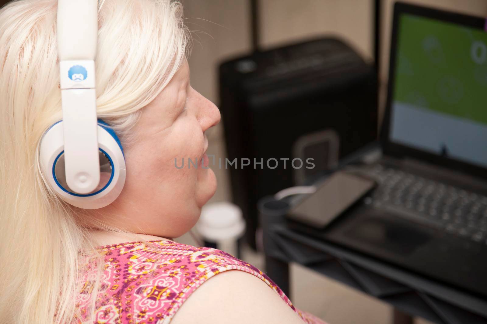 Blind woman listening to headphones while on the computer