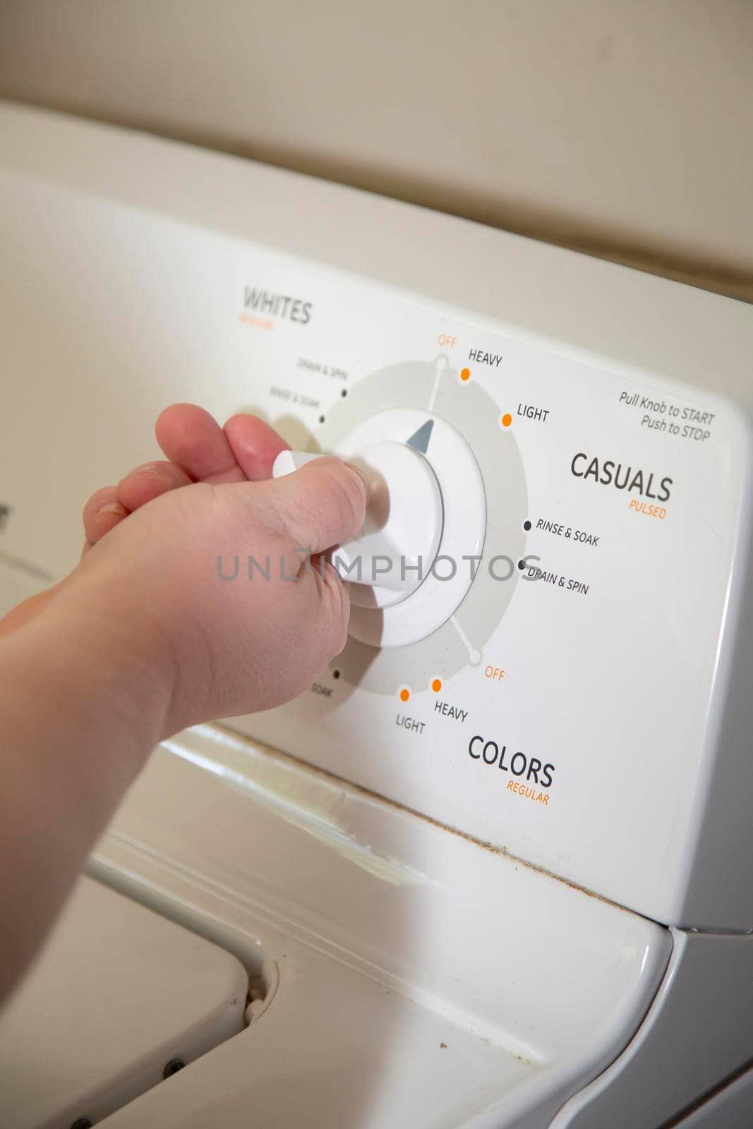 Woman turning a knob on a laundry washing machine