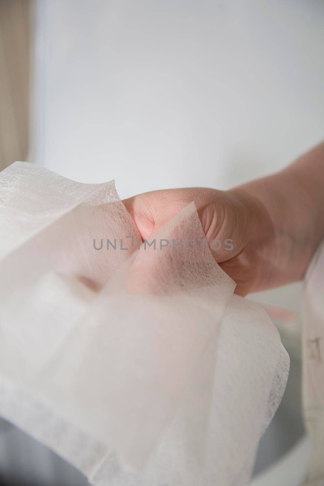 A woman's hand as she holds dryer sheets for laundry