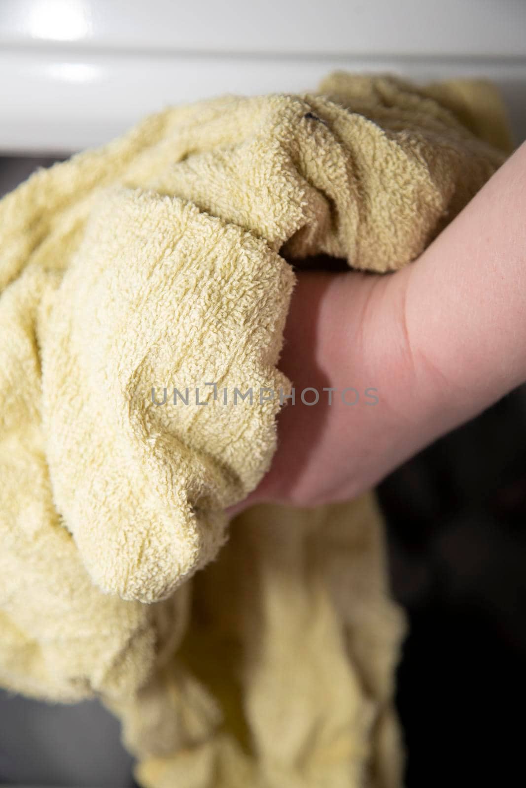 Damp yellow towel being tossed in a dryer