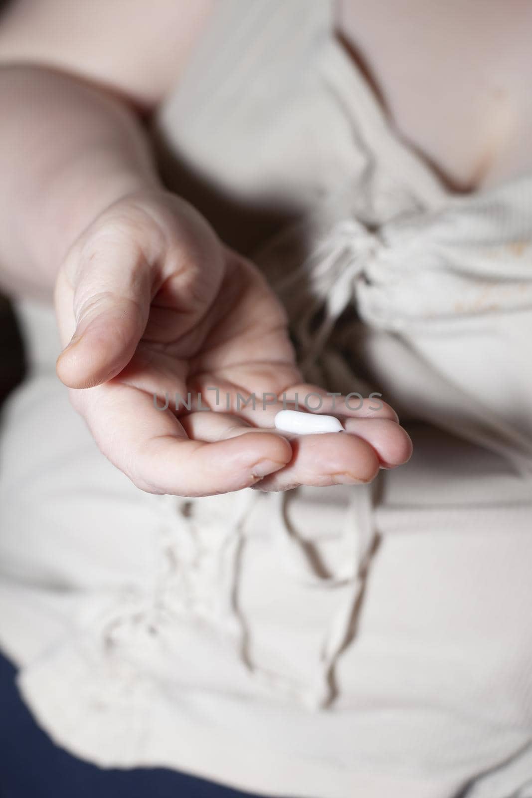 Woman with a strip of cream on her hand